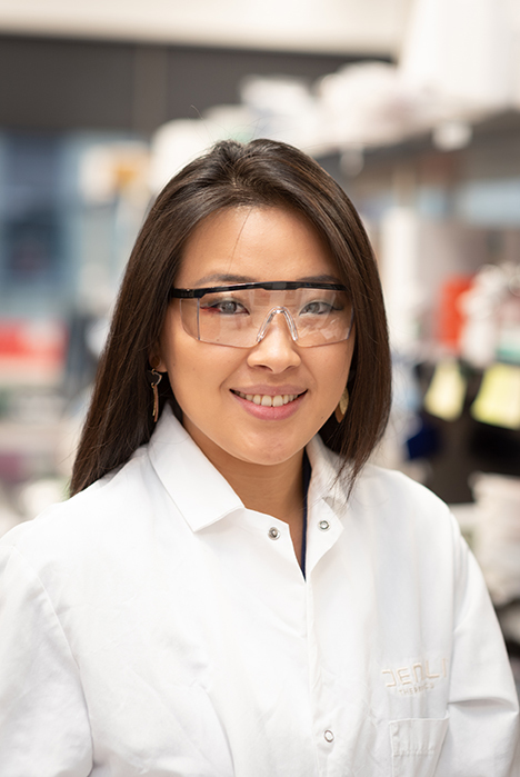 Person in lab coat wearing safety goggles