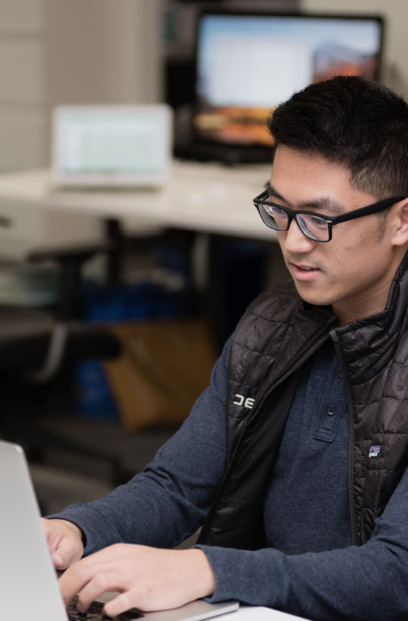 Person wearing glasses working on a laptop